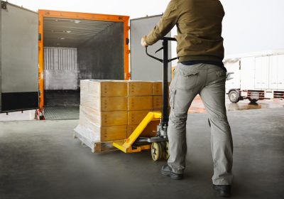 Workers Unloading Packaging Boxes on Pallets into The Cargo Container Trucks. Loading Dock. Shipping Warehouse. Delivery. Shipment Goods. Supply Chain. Warehouse Logistics Cargo Transport.