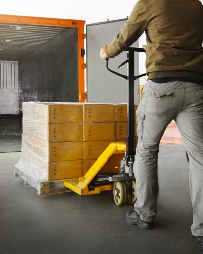 Workers Unloading Packaging Boxes on Pallets into The Cargo Container Trucks. Loading Dock. Shipping Warehouse. Delivery. Shipment Goods. Supply Chain. Warehouse Logistics Cargo Transport.